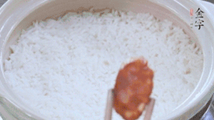 煮开后转小火，当米饭出现小孔时，铺上hth
麻辣香肠。