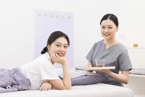 美容院按摩师为顾客端茶水